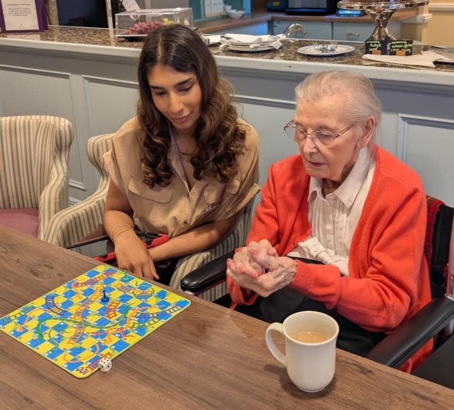 A resident and a visitor play Snakes and Ladders at Foxland Grange.